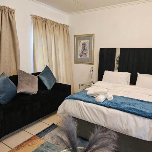 a bedroom with a bed and a couch at Premium Apartment In Fourways in Sandton