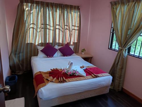 a bedroom with a large bed with purple pillows at Meranti Homestay in Bentong