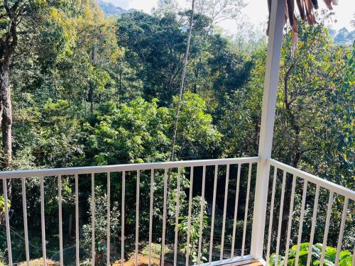 a balcony with a view of a forest at Historic Heaven wayanad in Vythiri