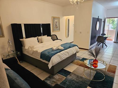 a bedroom with a large bed and a table at Premium Apartment In Fourways in Sandton
