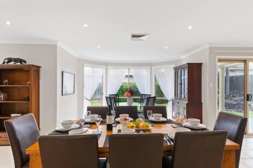a dining room with a table and chairs at 'Pineview Escape' Generous Comfort for Families in Shellharbour