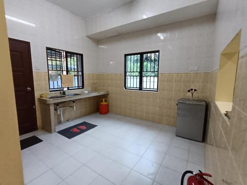 ein großes Bad mit einem Waschbecken und einem Spiegel in der Unterkunft Meranti Homestay in Bentong