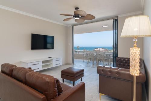 a living room with a couch and a flat screen tv at Shanthi Apartment 8 in Ballito