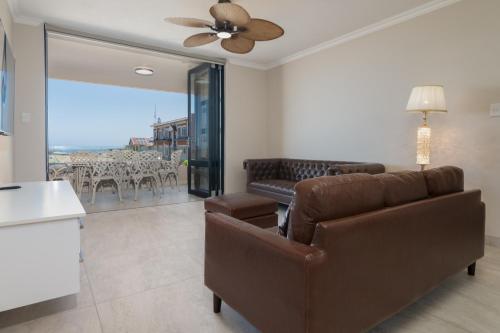 a living room with a couch and a ceiling fan at Shanthi Apartment 8 in Ballito