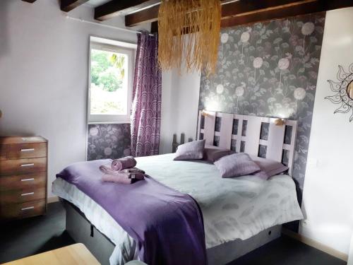 a bedroom with a large bed with purple curtains at "Chez Naty" chambres d'hôtes au Pays-Basque in Chéraute