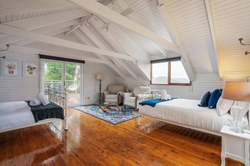 a large room with two beds and a couch at The Riverstone Luxury Eco Home in the Hills in Mudgee