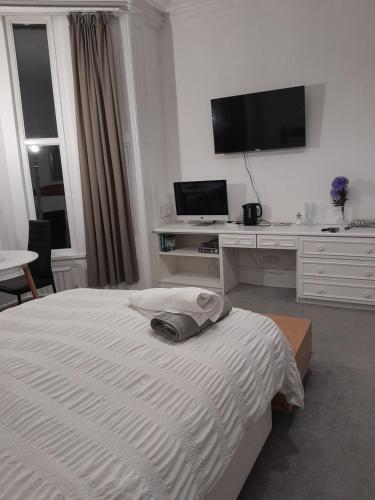 1 dormitorio con 1 cama y escritorio con TV en Large room near Singleton Hospital ensuite R6, en Swansea