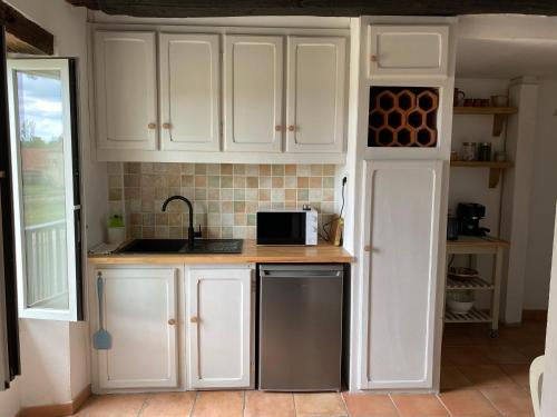 CatusにあるMas de Brugetの白いキャビネットとシンクと電子レンジを備えたキッチン