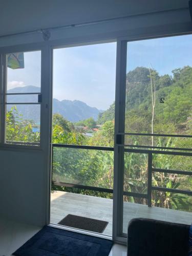 um quarto com uma janela com vista para as montanhas em ลอดจ์พังงา บูทีค em Phangnga