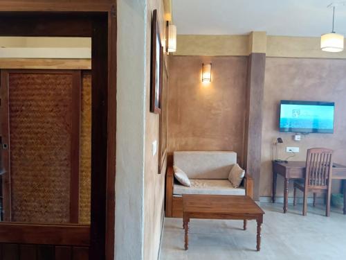 a living room with a couch and a table at AMARA AYURVEDA RETREAT- Overlooking Evergreen Western Ghats an ecologically sustainable living space in Kovalam in Kovalam