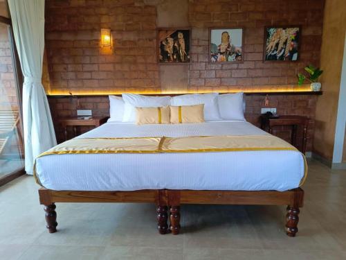 a bedroom with a bed with white sheets and pillows at AMARA AYURVEDA RETREAT- Overlooking Evergreen Western Ghats an ecologically sustainable living space in Kovalam in Kovalam
