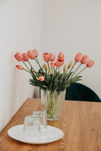 a vase of pink flowers sitting on a table at Verslo Klasė-easy to stay in Panevėžys