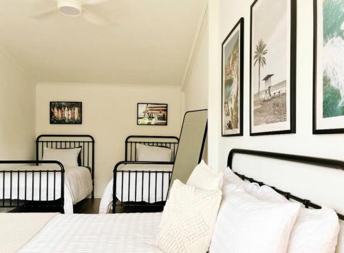 a bedroom with three beds and pictures on the wall at The Shack @ Port Elliot in Port Elliot