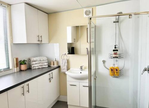 a white bathroom with a sink and a shower at The Shack @ Port Elliot in Port Elliot