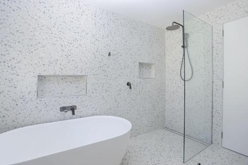 ein Badezimmer mit Badewanne und Glasdusche in der Unterkunft The Pawsome Getaway in Hawks Nest