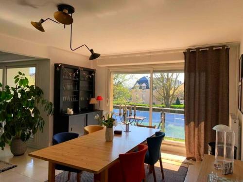 ein Esszimmer mit einem Tisch und einem großen Fenster in der Unterkunft Appartement spacieux, calme et lumineux. in Caen