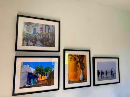a group of framed pictures on a wall at Appartement spacieux, calme et lumineux. in Caen