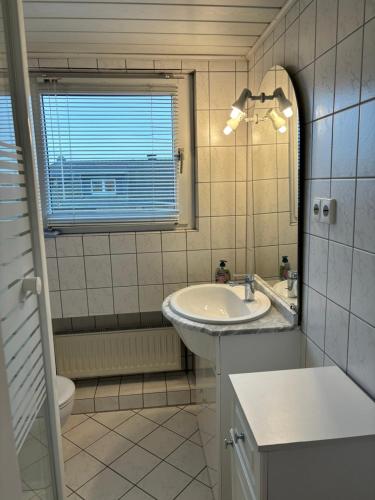 y baño con lavabo, aseo y espejo. en Charmante DG Whg Zentrumsnah, en Mönchengladbach