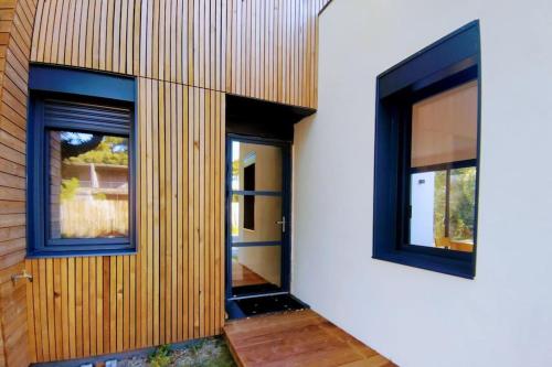 2 fenêtres sur le côté d'un bâtiment dans l'établissement Villa Cocoon Contis océan à 900m, à Lit-et-Mixe