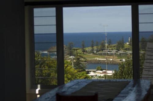a view of the ocean from a bedroom window at The Eagles Nest in Kiama