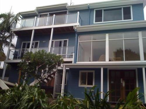 a blue house with large windows on the side of it at The Eagles Nest in Kiama