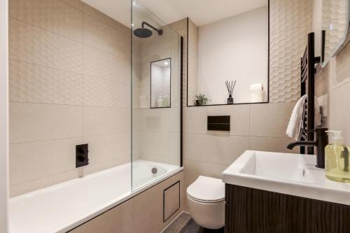 uma casa de banho com uma banheira, um WC e um lavatório. em Modern, comfy Town centre gem, near beach, parking em Bournemouth