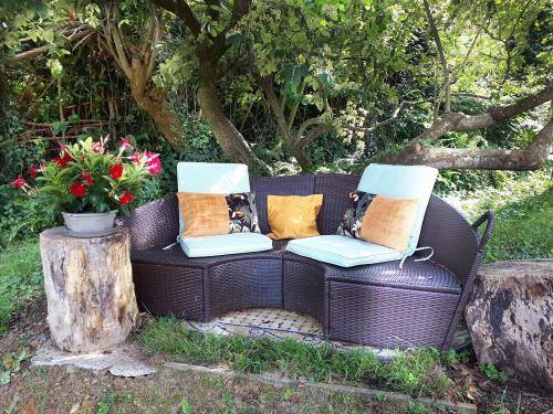 a brown wicker couch with pillows sitting on it at "Chez Naty" chambres d'hôtes au Pays-Basque in Chéraute