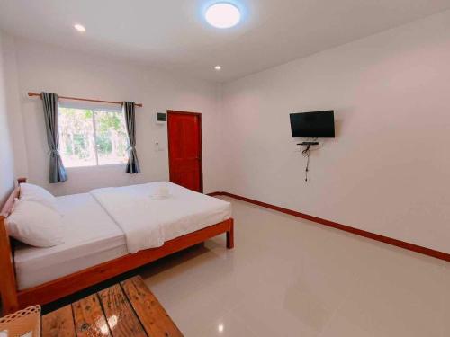 a bedroom with a bed and a television in it at ปาลินรีสอร์ท in Chiang Khan