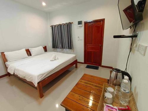 a bedroom with a bed and a coffee table at ปาลินรีสอร์ท in Chiang Khan