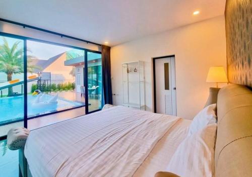 a bedroom with a large bed and a large window at Por House99 poolvilla in Hua Hin