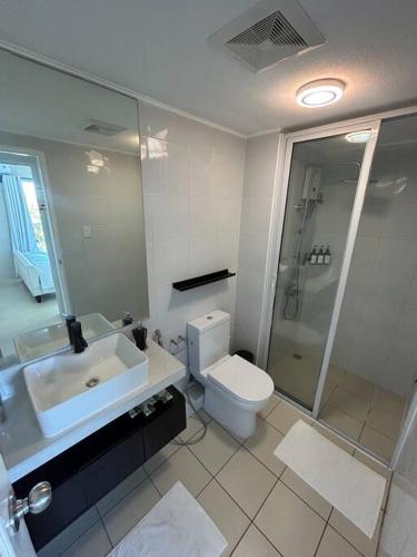 a bathroom with a sink and a toilet and a shower at Modern Oasis: Pool + Netflix in Manila