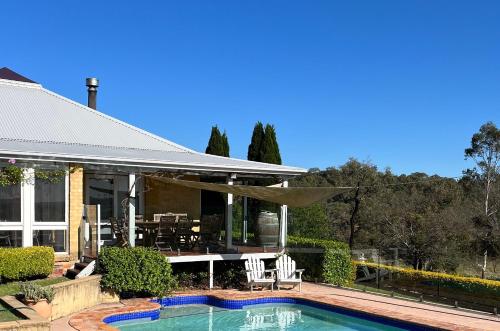 a house with a swimming pool in front of a house at Milla's Vineyard Estate in Pokolbin