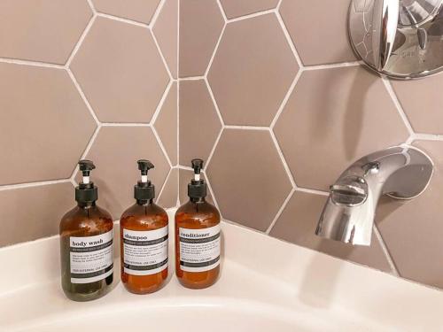 two bottles of honey sitting on a bathroom sink at Luxury 1BDR centrally located in Hollywood in Los Angeles