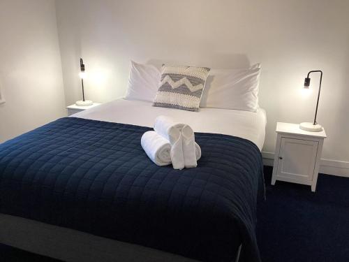 um quarto com uma cama com toalhas em Wharf Road Cottage em Coromandel Town