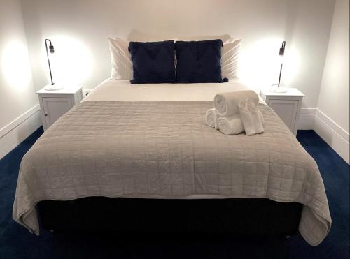 um quarto com uma cama com dois candeeiros e um bicho de peluche em Wharf Road Cottage em Coromandel Town