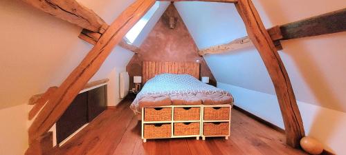 a attic room with a bed in the attic at Chambre nature in Thibivillers