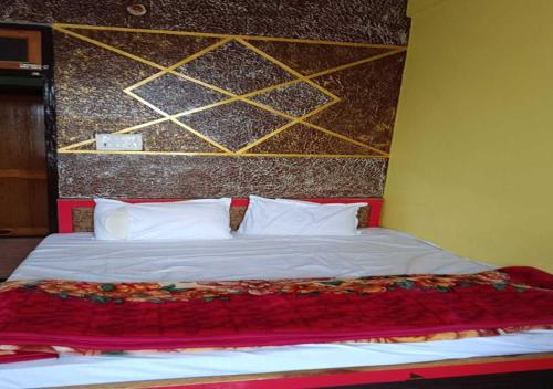 um quarto com uma cama grande e almofadas brancas em Dev Aagmann In em Ayodhya