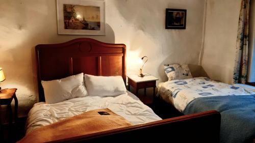 1 dormitorio con 2 camas y mesa con lámpara en Gite Les Chavautes - en Ciney