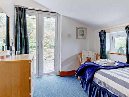 a bedroom with a bed and a desk and a window at 3 Bed in Welsh Newton Common 52149 in Welsh Newton Common