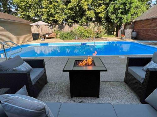 a patio with a fire pit next to a pool at Blue Moon Cottage - Music Room, Inground Pool in Owensboro