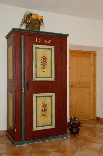 d'un meuble en bois orné de peintures. dans l'établissement Untermoar (Unterküchenmair), à Bressanone