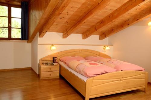 - une chambre dotée d'un lit avec des oreillers roses dans l'établissement Untermoar (Unterküchenmair), à Bressanone