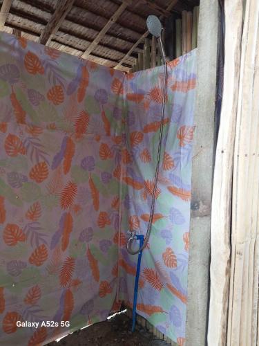 a shower curtain in a room with a shower at Kubo Inn & Beach Camp in El Nido