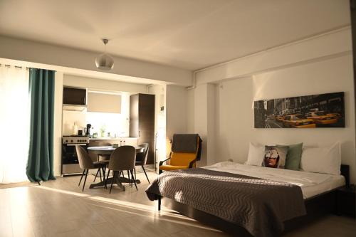 a bedroom with a bed and a table with chairs at Welcome to Bucharest Airport Residences & Therme-SELF CHECK-IN in Otopeni