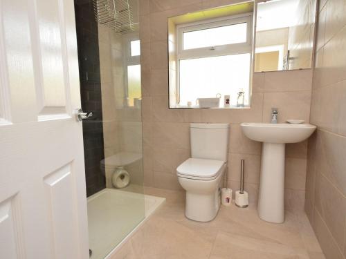 uma casa de banho com um WC, um lavatório e um espelho. em 2 Bed in Sutton On Sea 42804 em Anderby