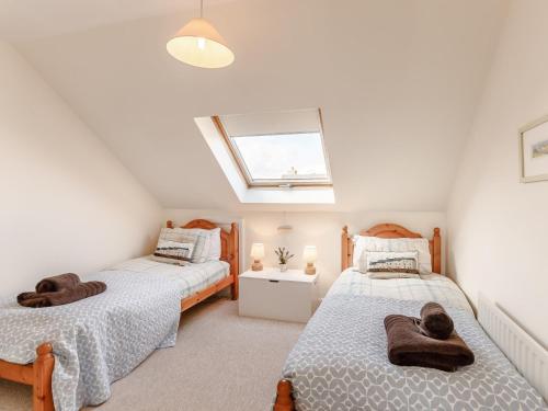 two beds in a attic bedroom with a skylight at 3 Bed in Bamburgh CN025 in Bamburgh