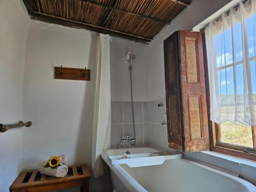 a bathroom with a bath tub and a window at Whipstock Guest Farm in McGregor