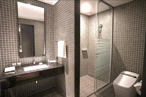 e bagno con servizi igienici, lavandino e doccia. di Sky View Hotel a Changwon
