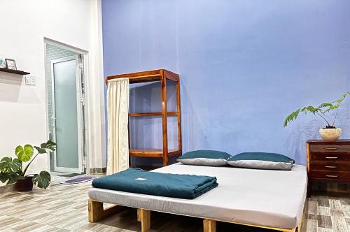 2 łóżka w pokoju z niebieską ścianą w obiekcie Nguyên căn Lazánia homestay ở Bình Minh Tây Ninh w mieście Ấp Bình Trung