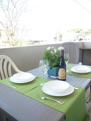 uma mesa com pratos e copos e uma garrafa de vinho em allinclusive em Lido di Jesolo